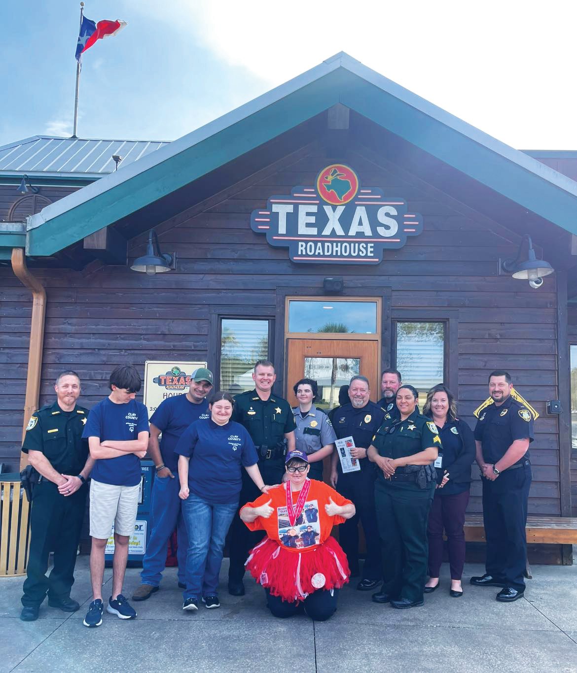 Members of the Clay County Sheriff’s Office and Orange Park Police Department join athletes and supporters of the Clay County Special Olympics team after they collected $12,009 in three nights at Texas Roadhouse during its annual Top-A-Cop program. The money will send county athletes to the Florida Special Olympics Games at Walt Disney World in May.